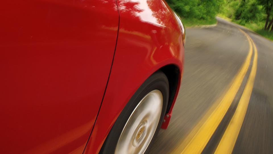 一辆红色汽车驾驶座前轮的特写.